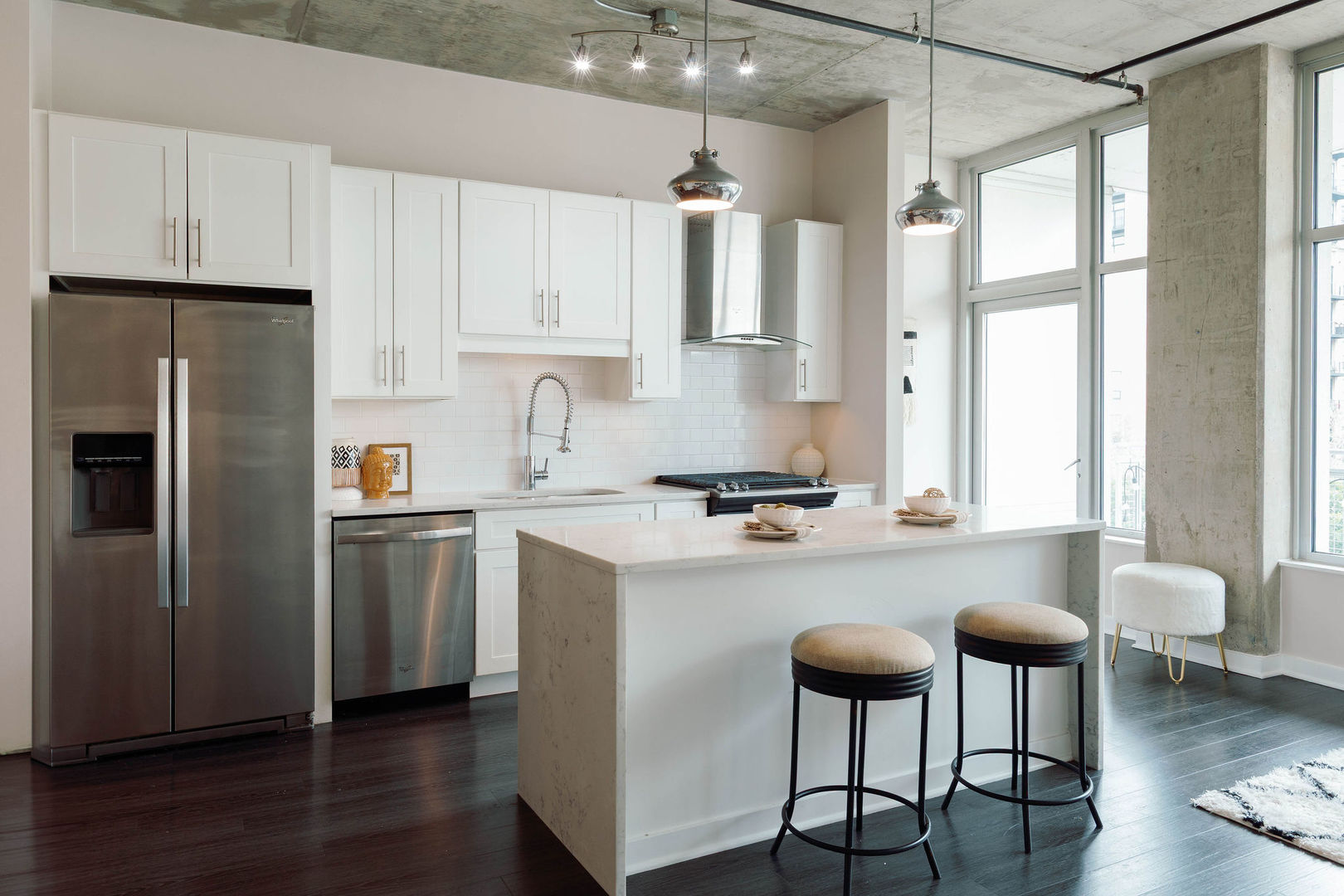 50 East 16th Street, Unit 402 Chicago, IL 60616 - Photo 16 of 33 a kitchen with stainless steel appliances a table chairs refrigerator and wooden cabinets