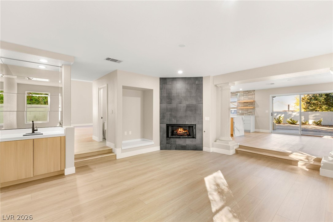 2104 Inverness Drive Henderson, NV 89074 - Photo 11 of 51 Unfurnished living room with a tile fireplace, light wood-type flooring, and recessed lighting