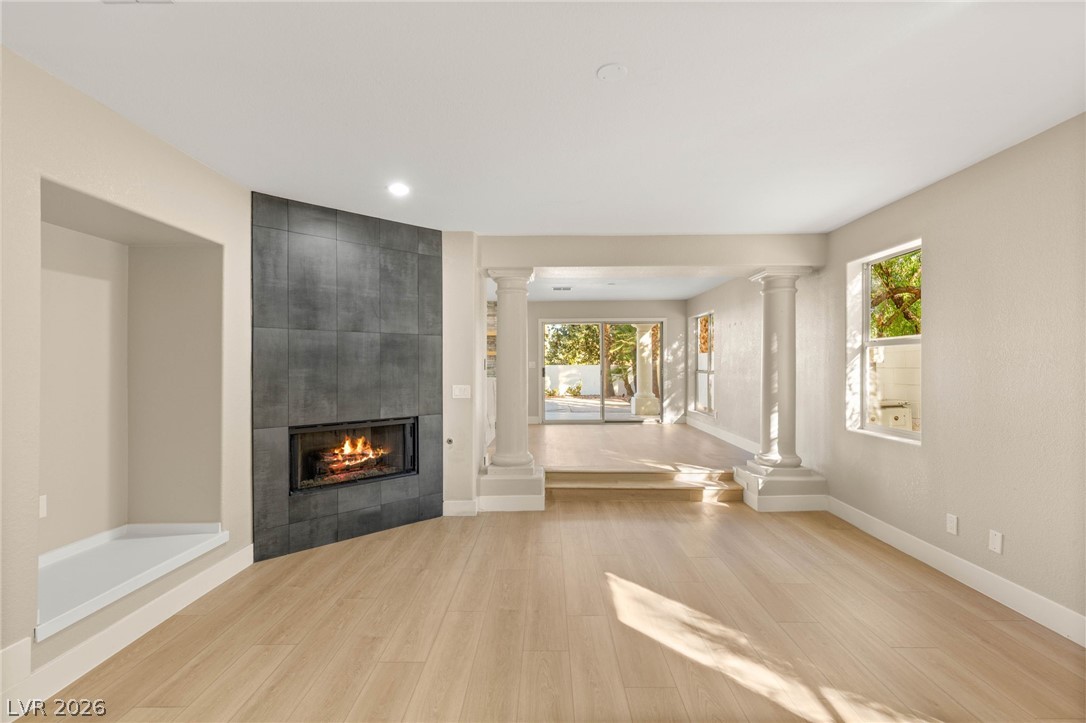 2104 Inverness Drive Henderson, NV 89074 - Photo 12 of 51 Unfurnished living room with a tile fireplace, light wood-type flooring, healthy amount of natural light, and recessed lighting