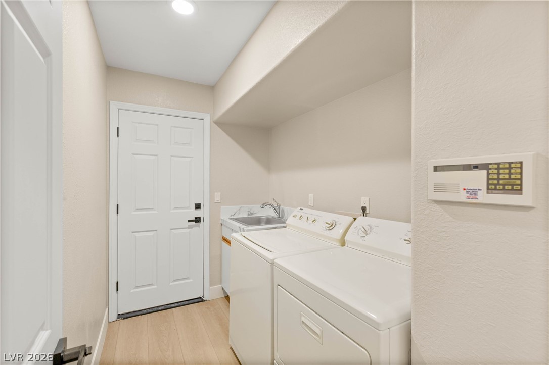 2104 Inverness Drive Henderson, NV 89074 - Photo 21 of 51 Laundry area featuring light wood-style flooring and washer and clothes dryer