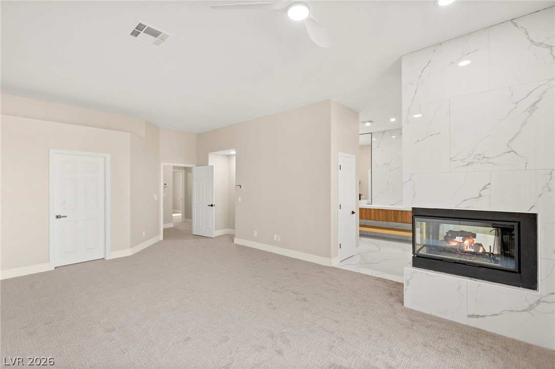2104 Inverness Drive Henderson, NV 89074 - Photo 27 of 51 Unfurnished living room featuring a premium fireplace, recessed lighting, a ceiling fan, and light colored carpet
