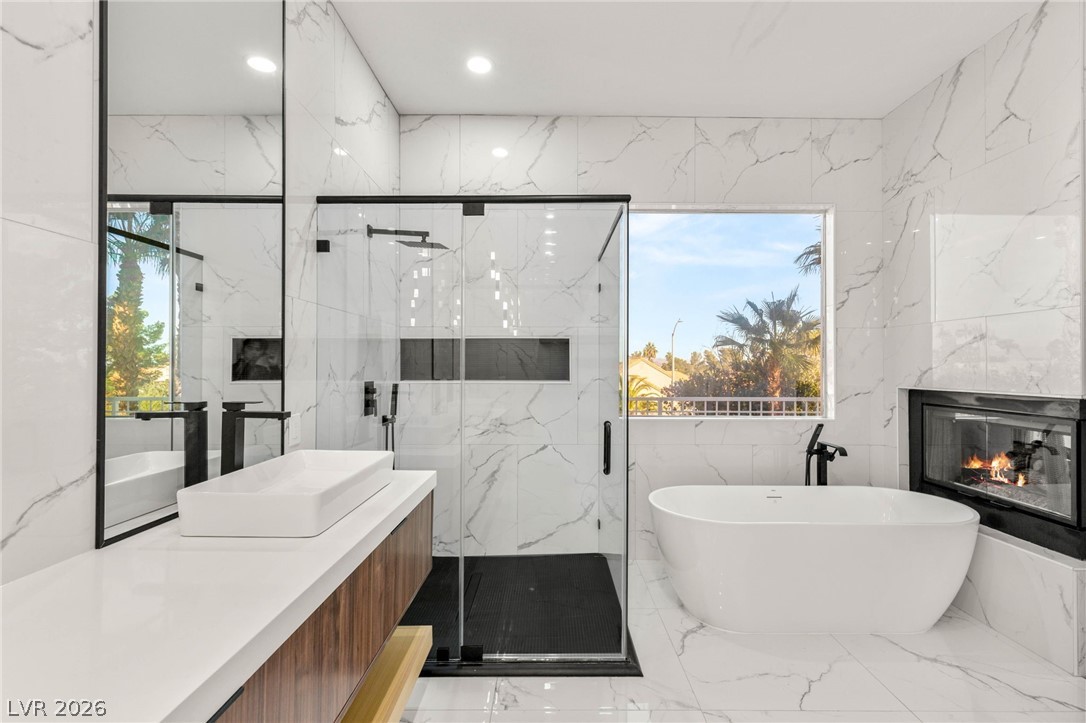 2104 Inverness Drive Henderson, NV 89074 - Photo 30 of 51 Full bathroom with vanity, a freestanding tub, a marble finish shower, a fireplace, and healthy amount of natural light