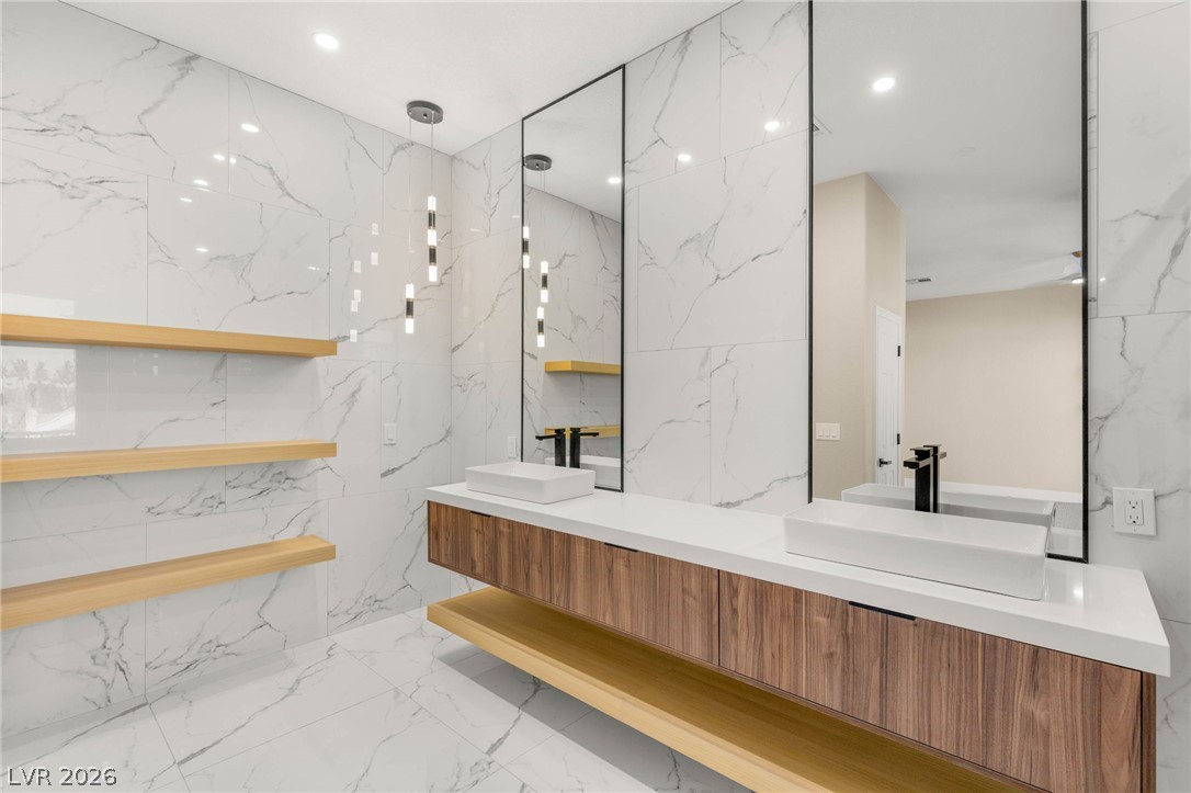 2104 Inverness Drive Henderson, NV 89074 - Photo 32 of 51 Bathroom with light marble finish flooring, double vanity, stone wall, and recessed lighting