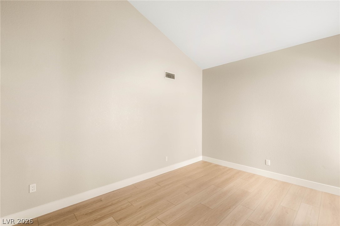 2104 Inverness Drive Henderson, NV 89074 - Photo 39 of 51 Empty room featuring light wood-style flooring and lofted ceiling