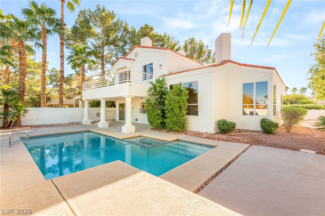 2104 Inverness Drive Henderson, NV 89074 - Photo 40 of 51 Back of house with a chimney, a patio area, a pool with connected hot tub, and stucco siding