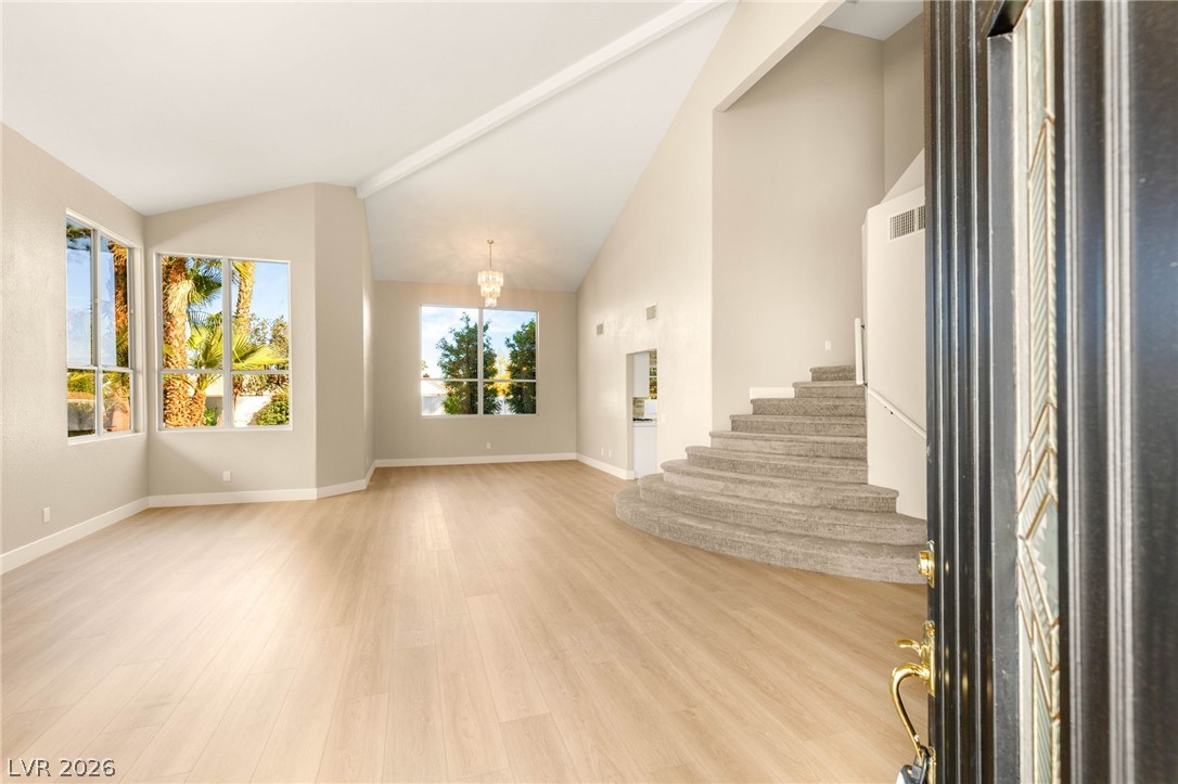 2104 Inverness Drive Henderson, NV 89074 - Photo 5 of 51 Foyer featuring stairway, light wood-type flooring, a chandelier, and high vaulted ceiling