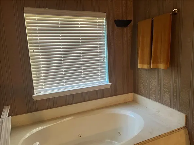 a bathroom with a bathtub and a window