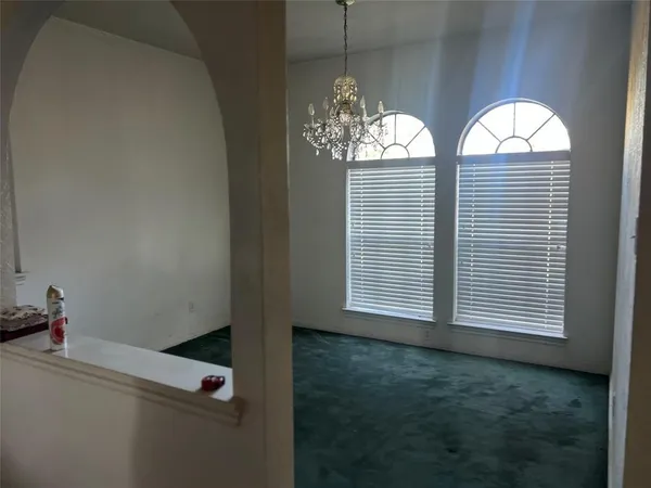 a view of hall way with furniture and chandelier
