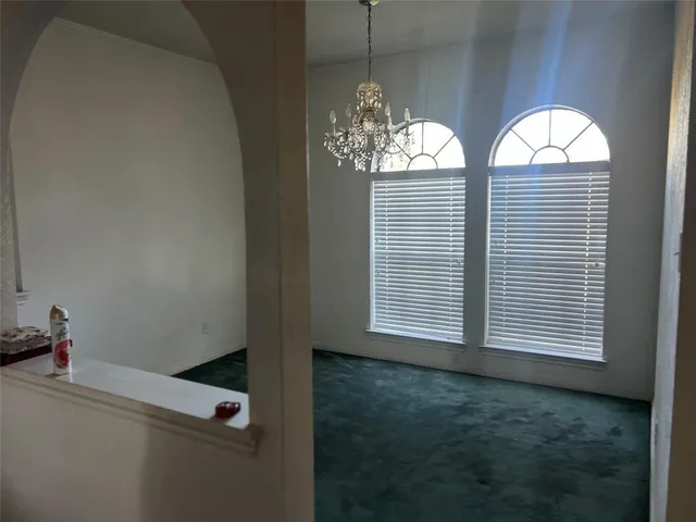 a view of hall way with furniture and chandelier