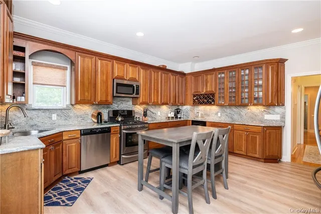 a kitchen with granite countertop wooden cabinets and stainless steel appliances