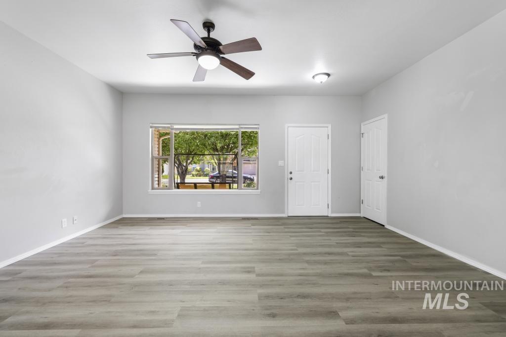 1183 Cortes Loop Twin Falls, ID 83301 - Photo 13 of 30 Spacious room featuring wood-finish flooring, a contemporary ceiling fan with integrated lighting, and neutral wall tones