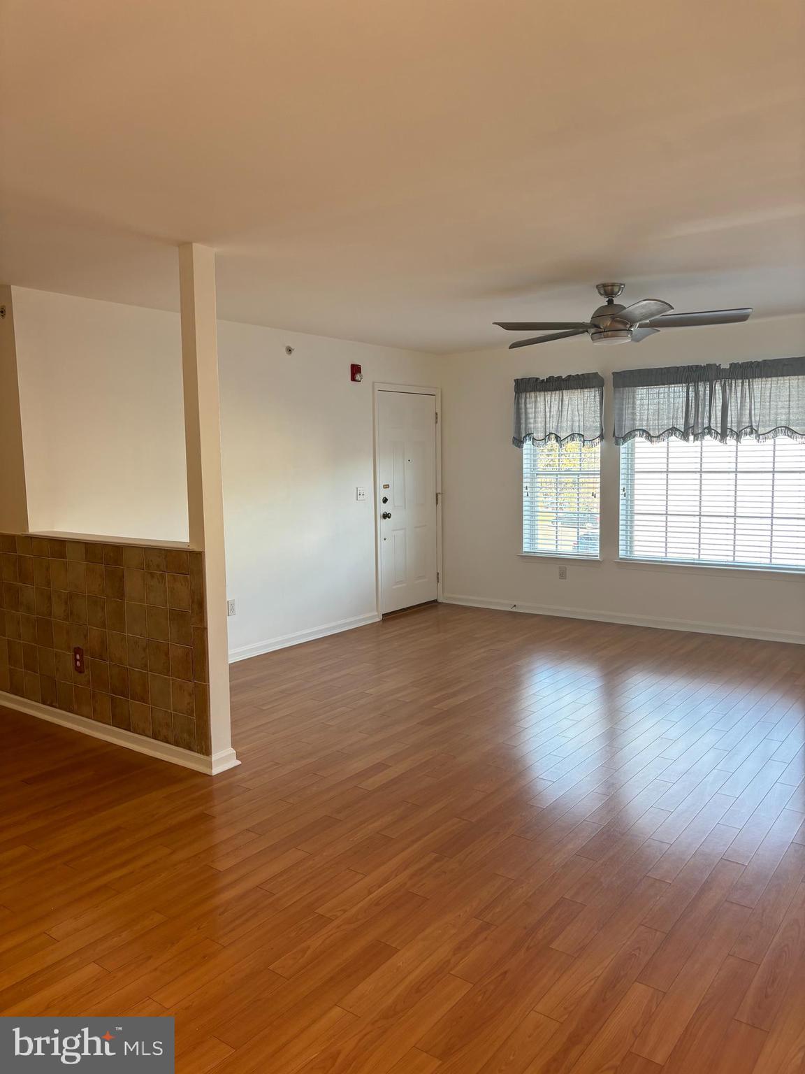 9228 Blue Grass Road, Unit 4 Philadelphia, PA 19114 - Photo 11 of 17 an empty room with wooden floor and windows