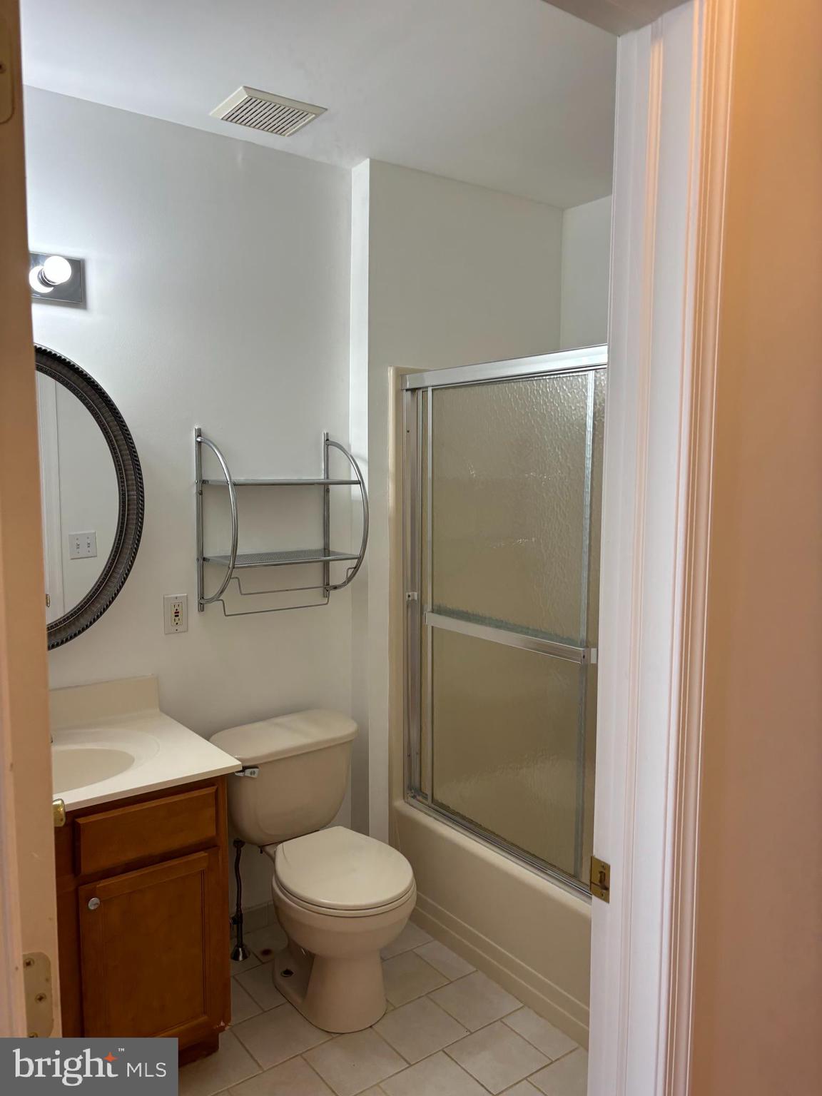 9228 Blue Grass Road, Unit 4 Philadelphia, PA 19114 - Photo 13 of 17 a bathroom with a granite countertop toilet a sink and a mirror