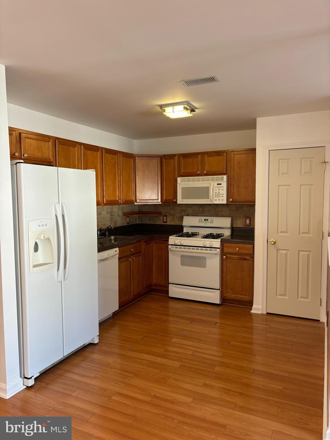 9228 Blue Grass Road, Unit 4 Philadelphia, PA 19114 - Photo 4 of 17 a kitchen with stainless steel appliances a refrigerator and a stove top oven