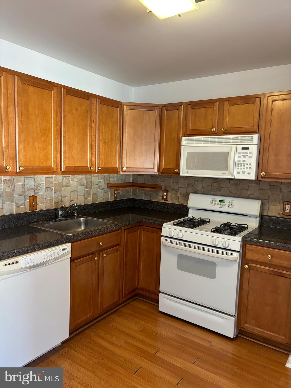 9228 Blue Grass Road, Unit 4 Philadelphia, PA 19114 - Photo 9 of 17 a kitchen with a stove a sink and a window