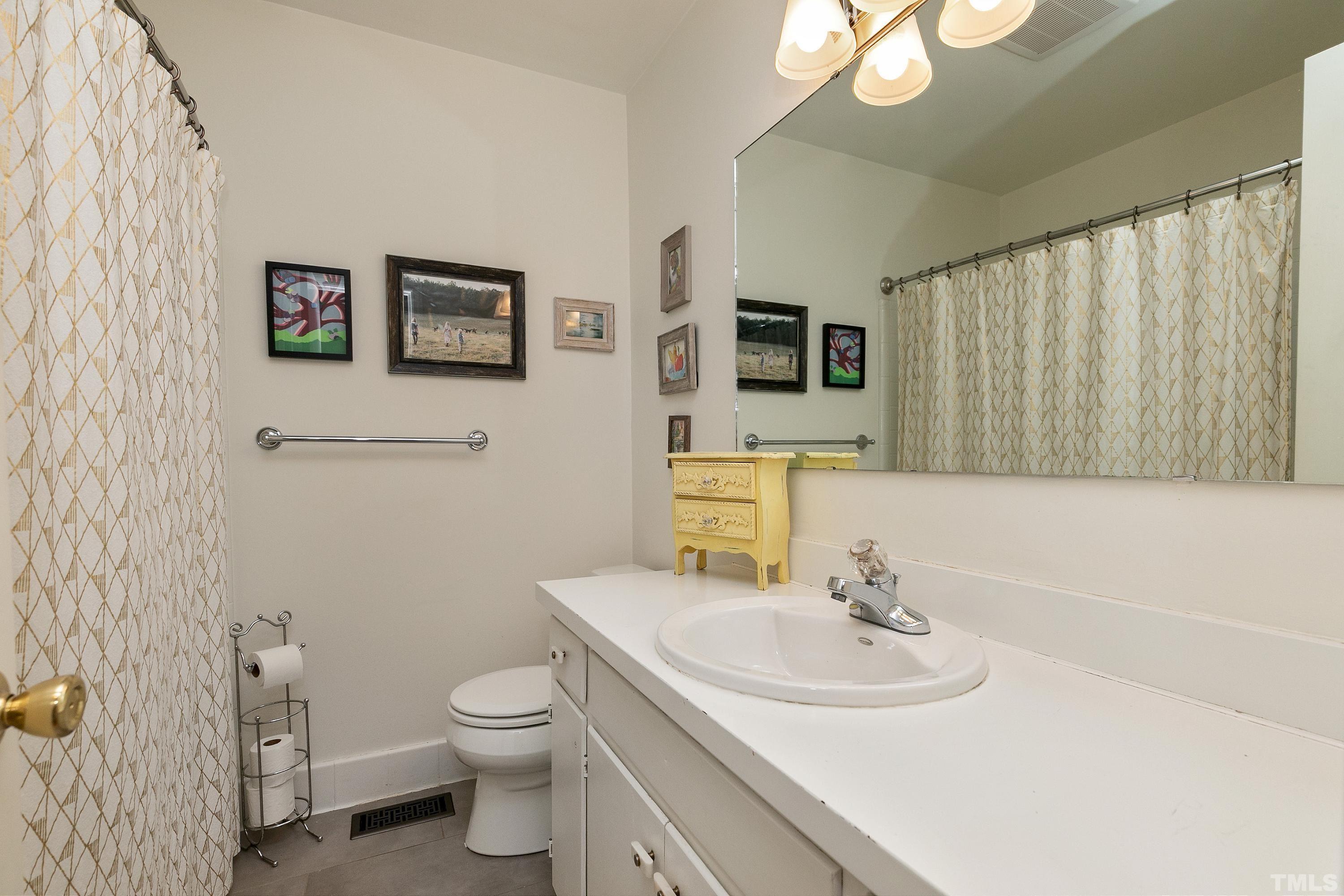 1300 Kingston Ridge Road Cary, NC 27511 - Photo 23 of 40 a bathroom with a toilet a sink and a mirror