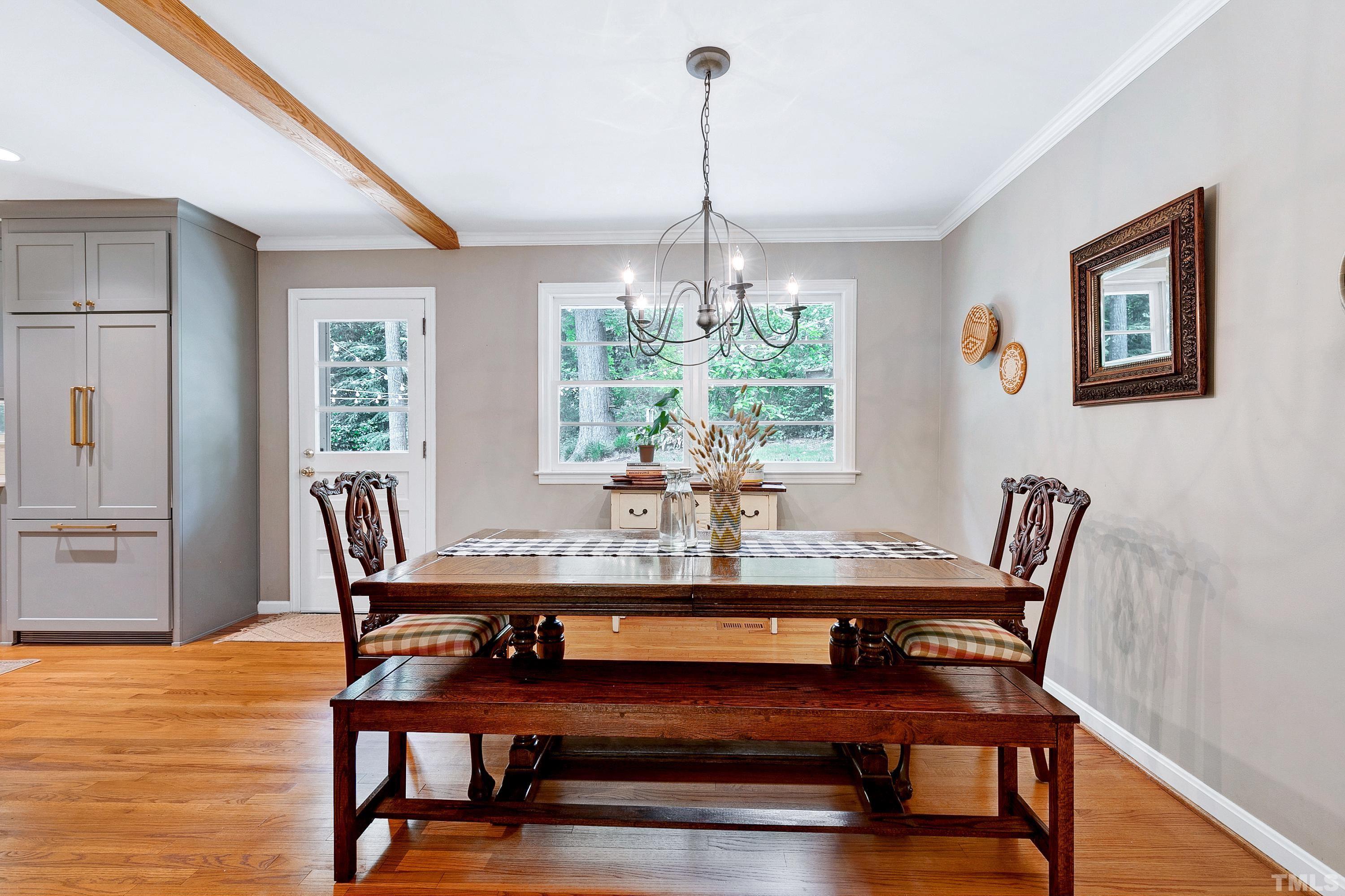 1300 Kingston Ridge Road Cary, NC 27511 - Photo 6 of 40 a dining room with furniture a chandelier and wooden floor