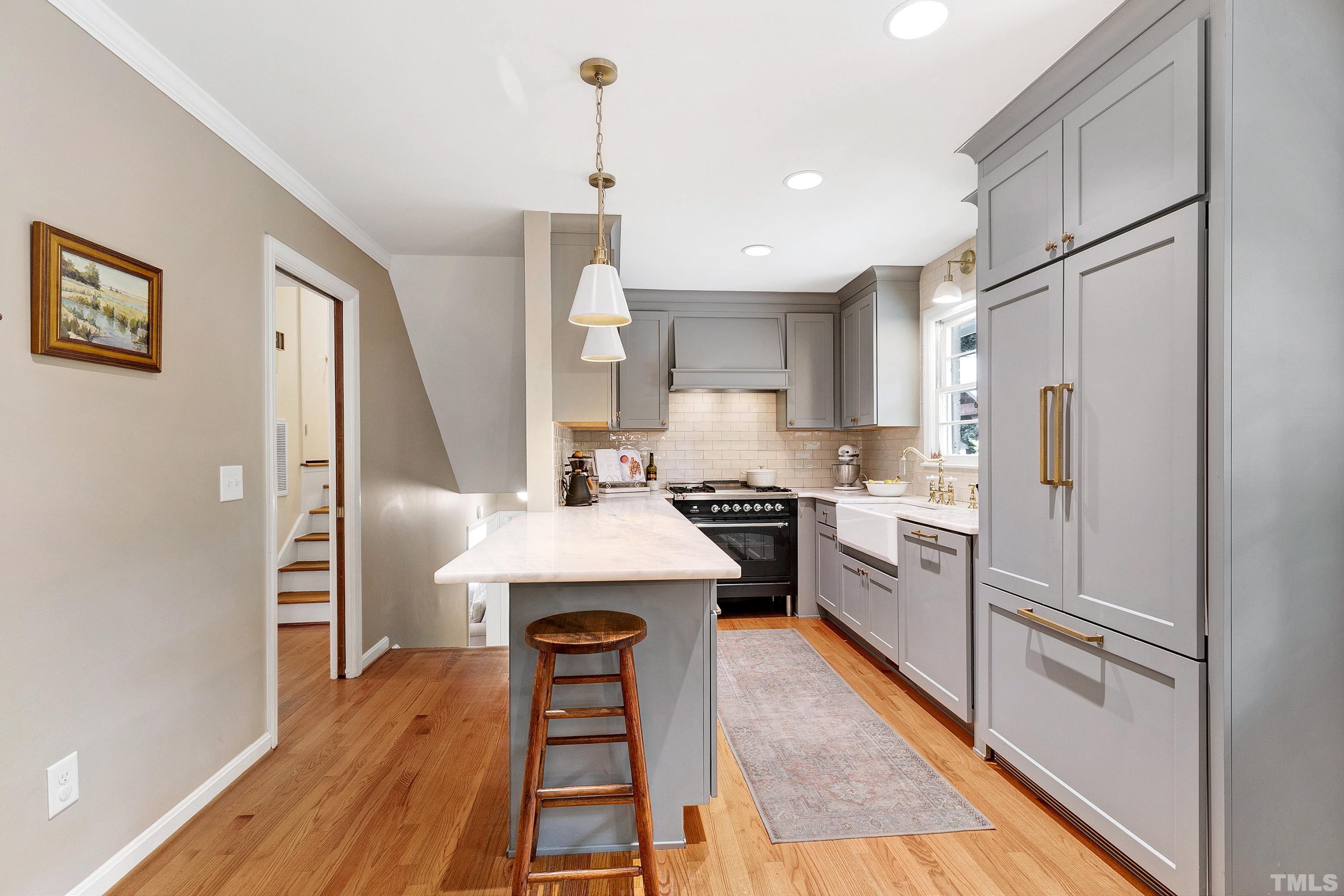 1300 Kingston Ridge Road Cary, NC 27511 - Photo 8 of 40 a kitchen with white cabinets and stainless steel appliances
