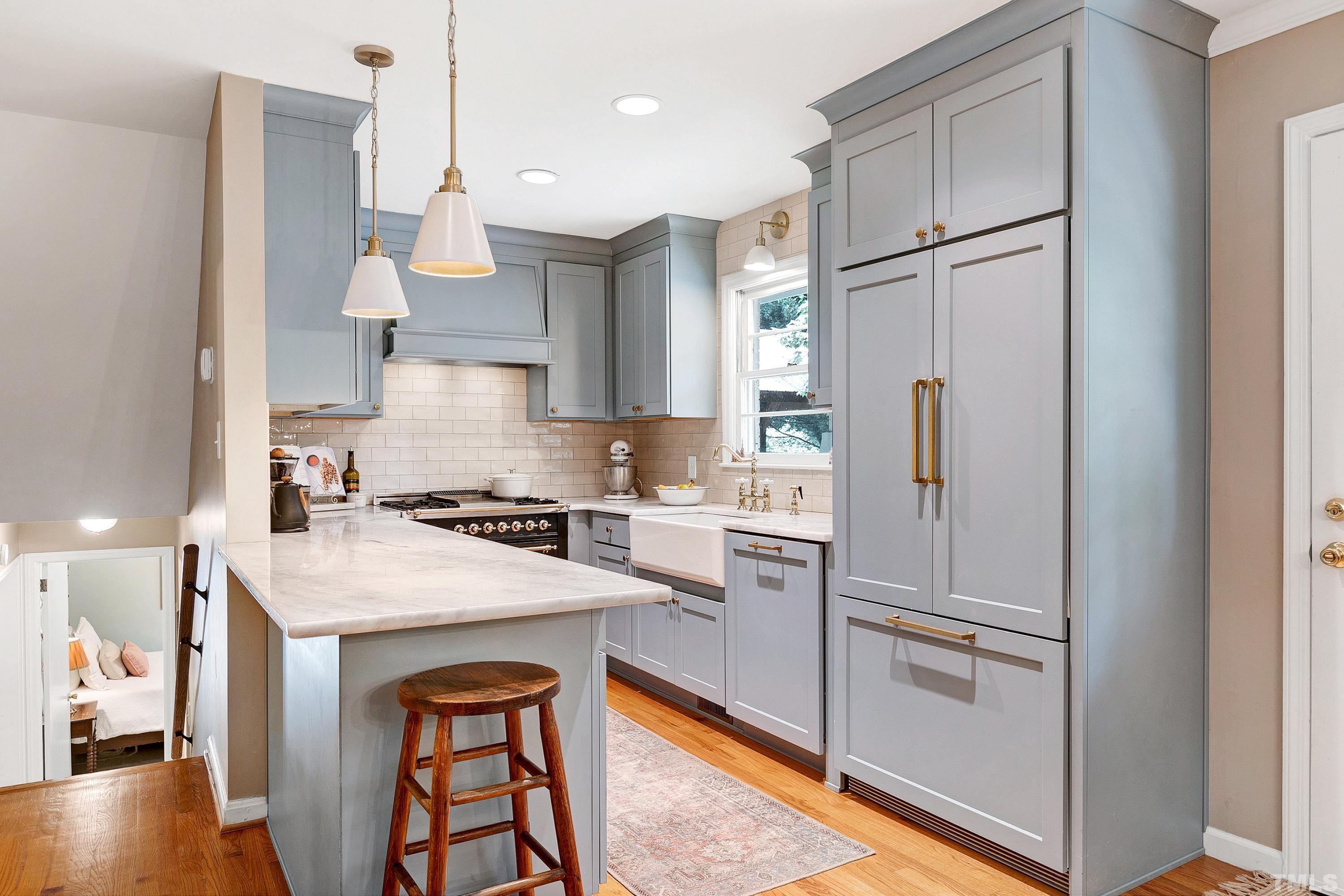 1300 Kingston Ridge Road Cary, NC 27511 - Photo 9 of 40 a kitchen with stainless steel appliances granite countertop a refrigerator a sink dishwasher a stove with white cabinets and wooden floor