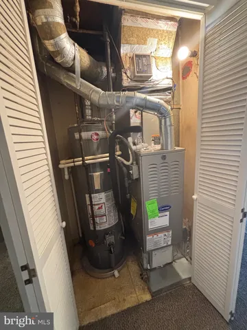 a view of a house with a barbeque grill and wooden fence