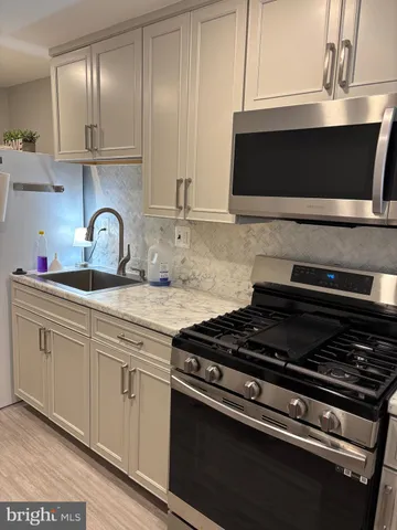 a kitchen with granite countertop a stove and a sink