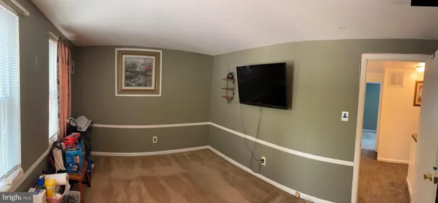 a view of a livingroom with wooden floor and a flat screen tv