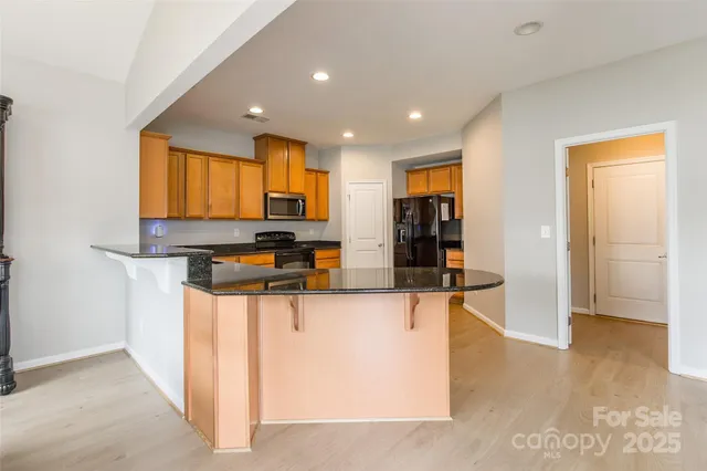 a kitchen with stainless steel appliances granite countertop a refrigerator and a stove top oven