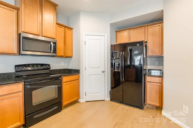 a kitchen with stainless steel appliances granite countertop a refrigerator stove and microwave