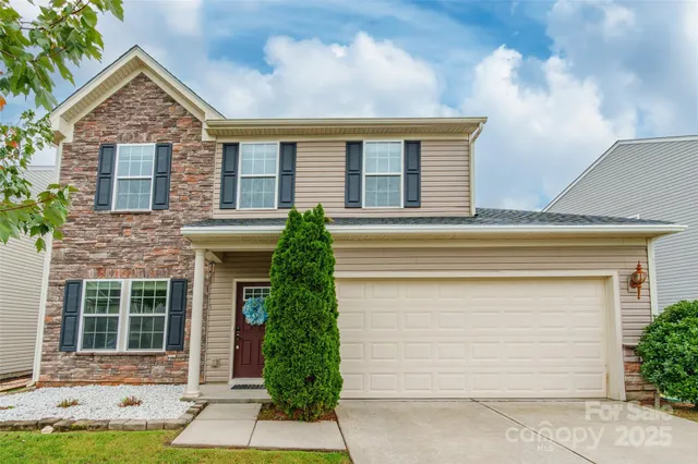 a front view of a house with a yard and potted plants