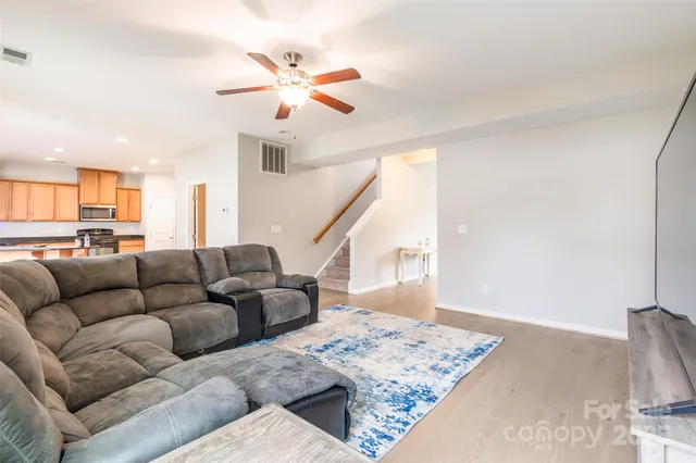a living room with furniture and a view of kitchen