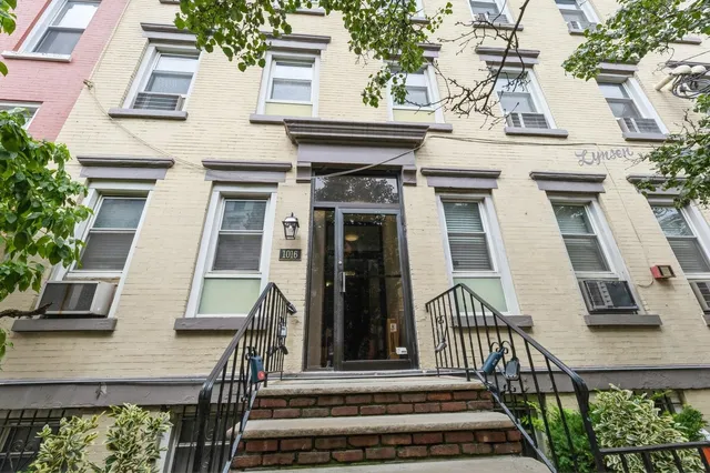 a view of a building with chairs potted plants and a bench