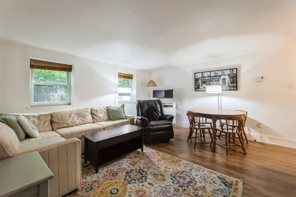a living room with furniture wooden floor and a window