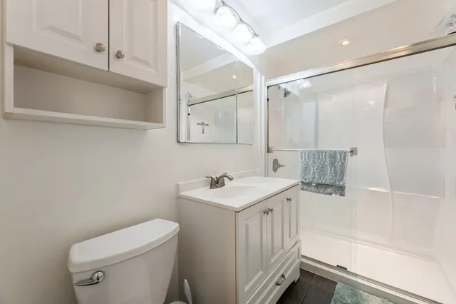 a bathroom with a sink a toilet and shower