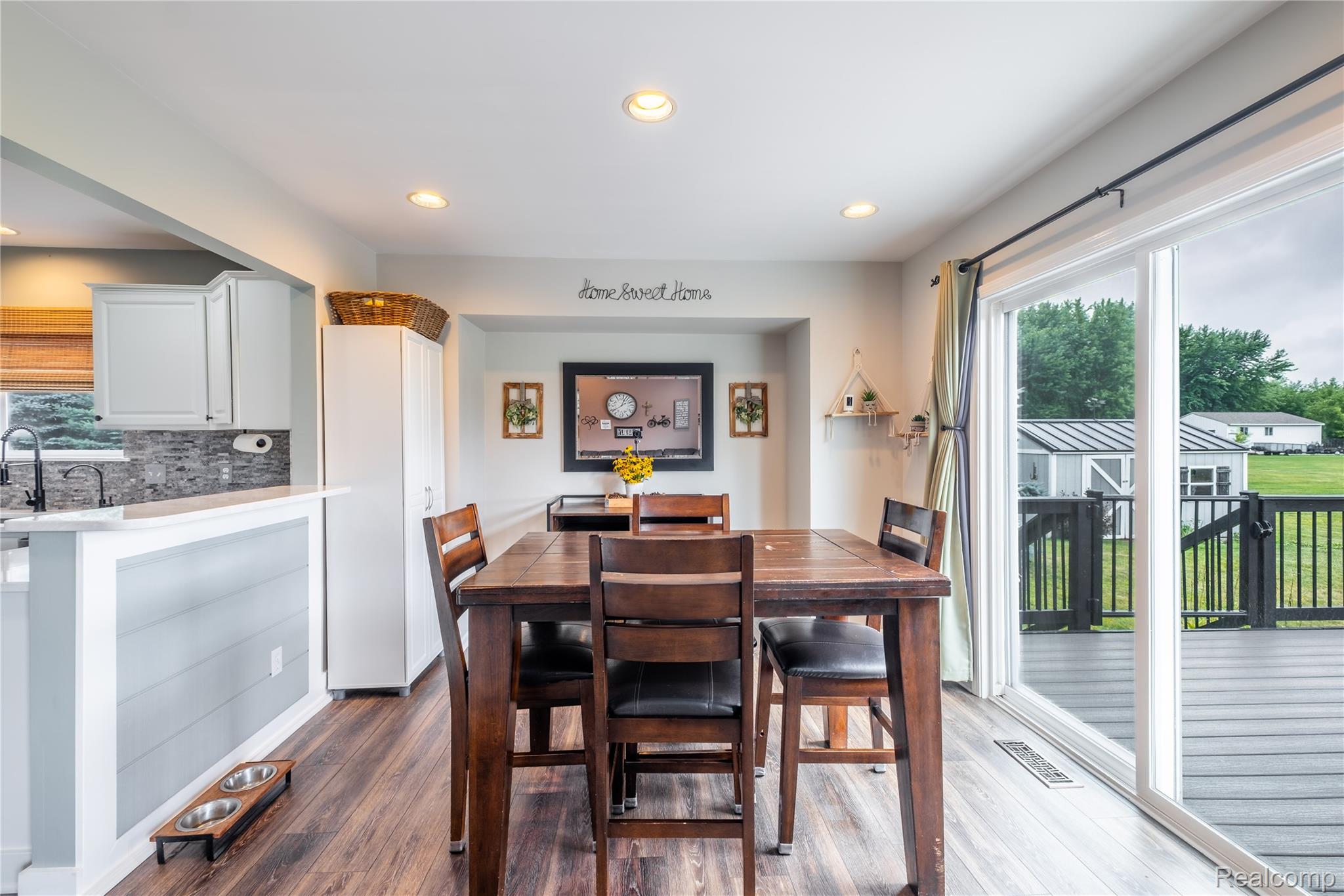 13063 Seymour Road Gaines, MI 48436 - Photo 10 of 29 Recessed ceiling lighting, wood-finish flooring, white cabinetry, sliding glass door, and an exterior composite deck