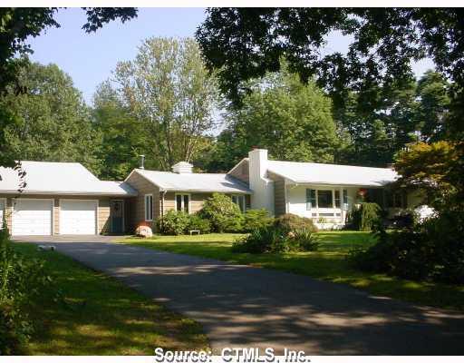 Exterior Front. NEWER DRIVEWAY LEADS TO A THREE CAR GARAGE. STONE WALL SURROUNDS 3/4 OF THE YARD FOR PRIVACY.