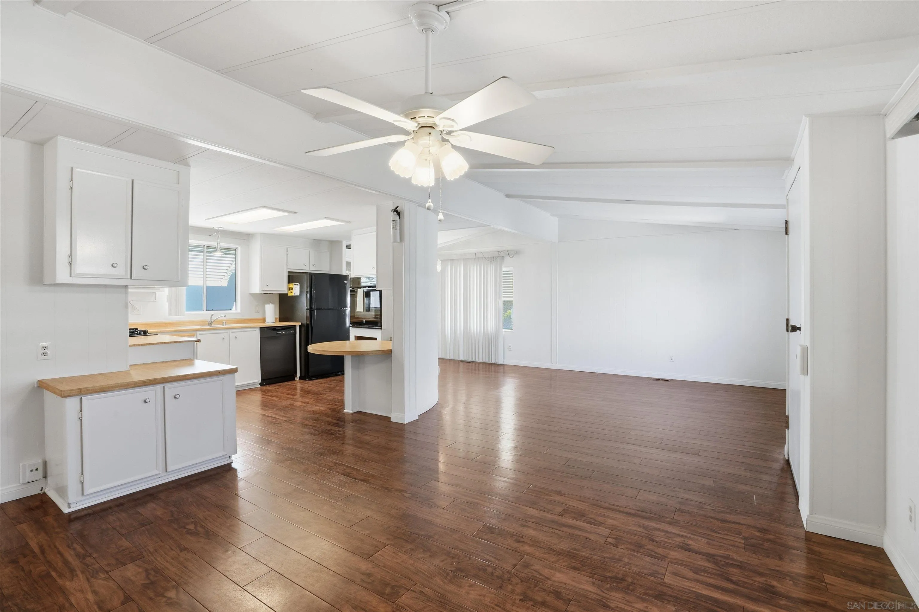9255 North Magnolia Avenue, Unit 339 Santee, CA 92071 - Photo 27 of 51 a view of an empty room and kitchen with wooden floor