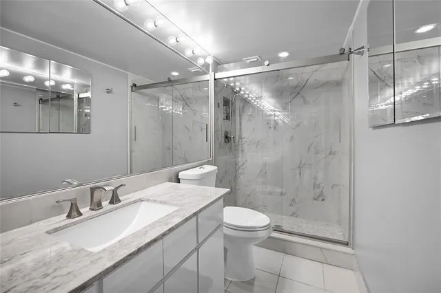 a bathroom with a granite countertop sink toilet and shower