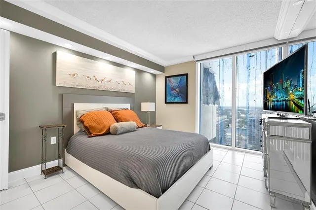 a bedroom with a bed and large windows