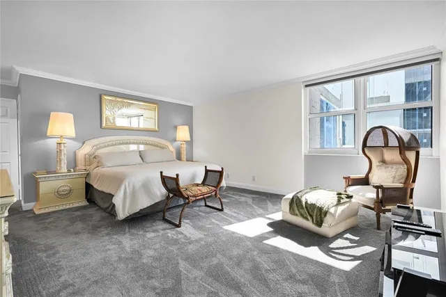 a bedroom with a bed and a large window