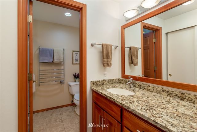 a bathroom with a granite countertop sink and a mirror