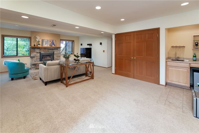 a living room with furniture a fireplace and a open kitchen view
