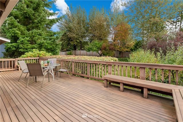 a view of a roof deck with table and chairs and wooden floor