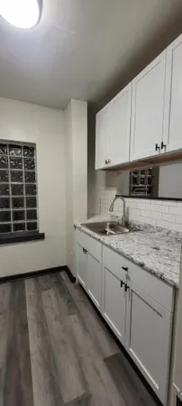 a kitchen with granite countertop white cabinets and a sink