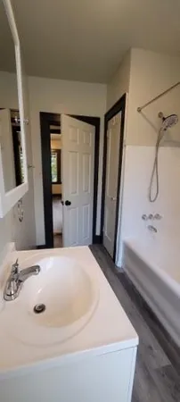 a bathroom with a tub sink and mirror