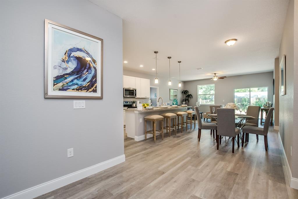 621 Paddock Street Orlando, FL 32833 - Photo 3 of 25 a dining room with wooden floor and a kitchen view