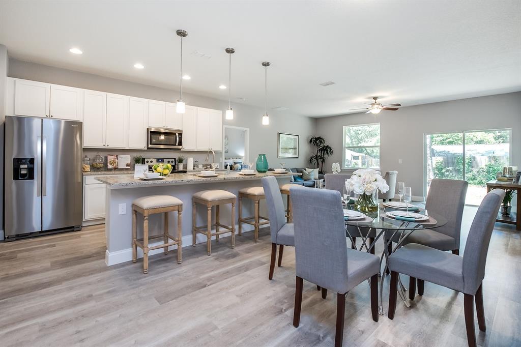 621 Paddock Street Orlando, FL 32833 - Photo 4 of 25 a view of a dining room with furniture a kitchen and chandelier