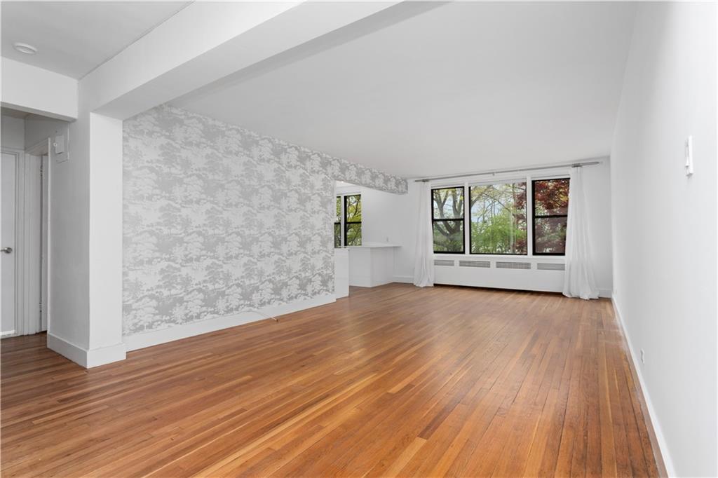 9511 Shore Road, Unit 101 Brooklyn, NY 11209 - Photo 1 of 8 an empty room with wooden floor and windows
