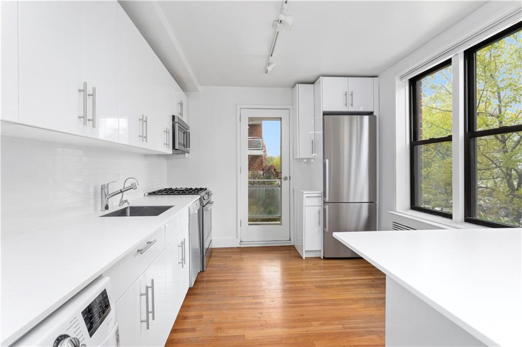 9511 Shore Road, Unit 101 Brooklyn, NY 11209 - Photo 3 of 8 a kitchen with granite countertop a sink and a refrigerator
