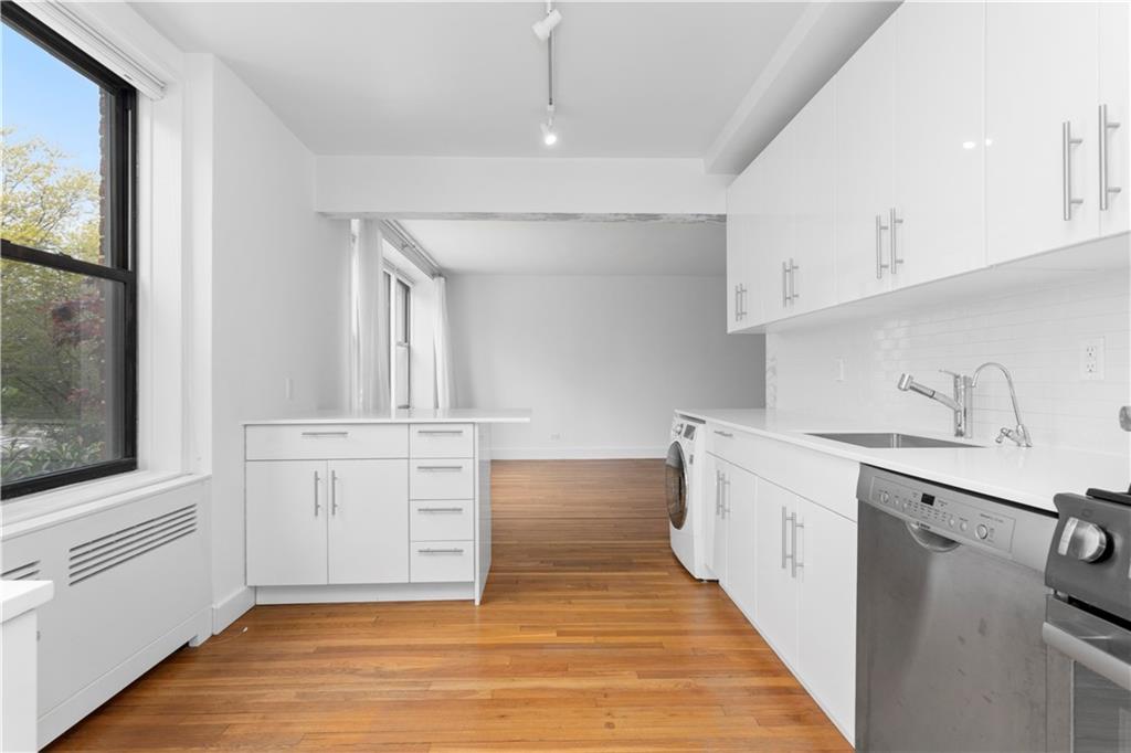 9511 Shore Road, Unit 101 Brooklyn, NY 11209 - Photo 4 of 8 a kitchen with white cabinets and sink