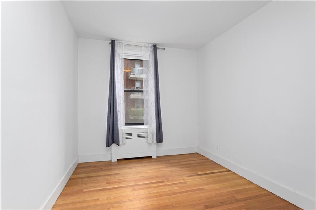 9511 Shore Road, Unit 101 Brooklyn, NY 11209 - Photo 6 of 8 a view of an empty room with wooden floor and a window